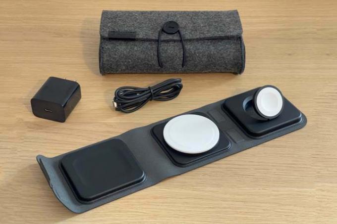 O carregador de viagem 3 em 1 Mophie com MagSafe, mostrado com estojo de viagem e adaptador de energia em uma mesa.