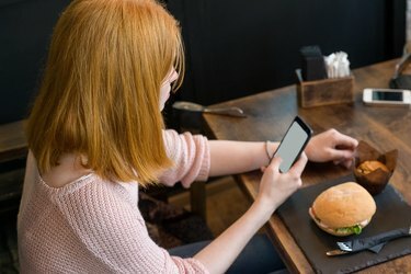 Gadis duduk dan melihat telepon