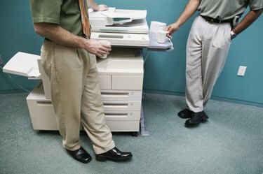 Lavt snitbillede af to forretningsmænd, der står ved en fotokopimaskine