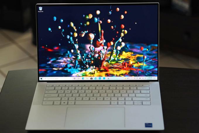 מחשב נייד Dell XPS 15 OLED יושב על שולחן קטן.