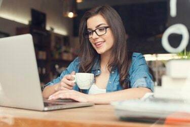 Vacker hipster kvinna som använder laptop på café