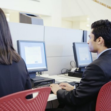 Lidé pracující na počítačových stanicích