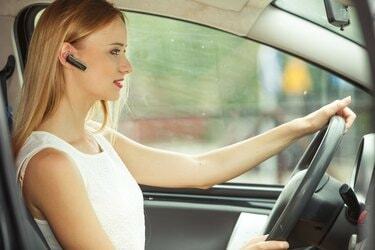 אישה נוהגת במכונית עם אוזניות