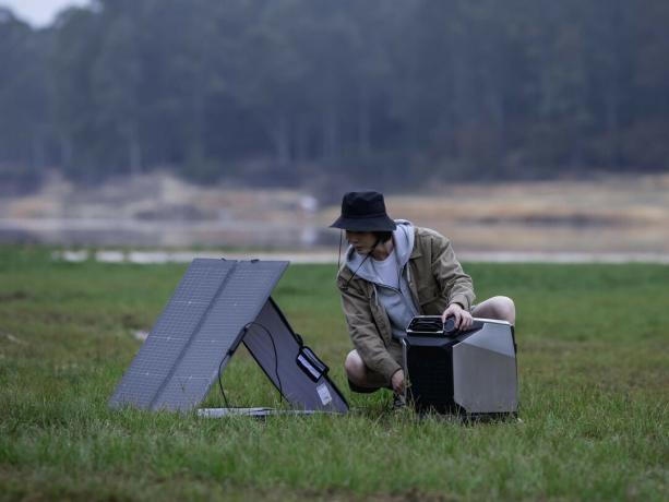 En campingvogn bruker en EcoFlow Wave med solcellepanel utendørs.