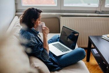 Imagen recortada de mujer usando laptop con pantalla en blanco