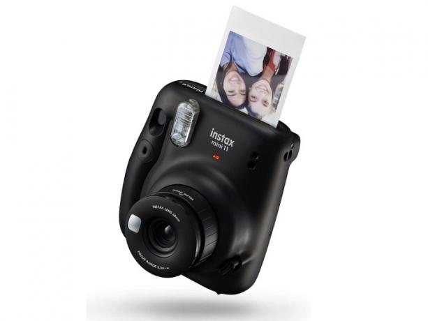 Die schwarze Version der Instax Mini 11 von Fujifilm beim Entwickeln eines Bildes.