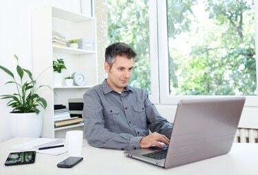 Jovem na mesa do escritório, trabalhando em um laptop