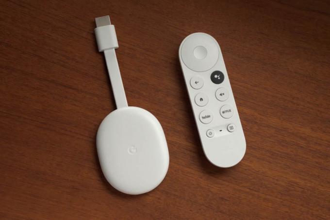 Un Chromecast bianco e un telecomando giacciono sul tavolo.