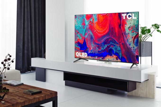 Google TV TCL 5-Series 4K QLED je umístěna v zábavním centru v obývacím pokoji.