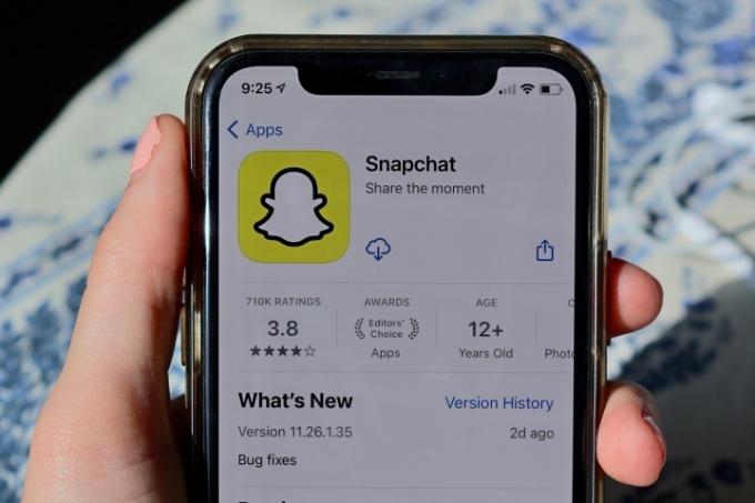Roka, ki drži telefon, na zaslonu katerega je prikazan vnos v trgovini z aplikacijami za aplikacijo Snapchat.