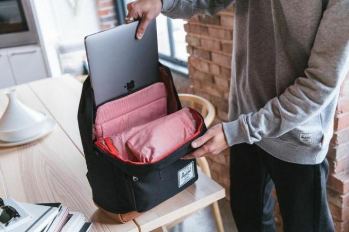 Nogen, der skubber en Macbook ned i Herschel Pop Quiz-rygsækken