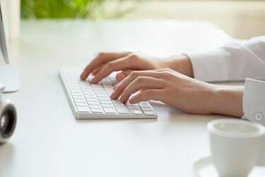 Manos de mujer escribiendo en el teclado de la computadora