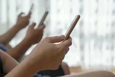 Shot van een groep onherkenbare mensen die hun mobiele telefoons samen thuis gebruiken