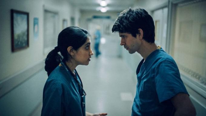 Dos médicos se miran cara a cara en el pasillo de un hospital en una escena de Esto me va a doler.