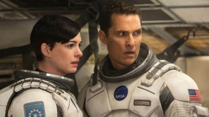 Matthew McConaughey a Anne Hathway zvědavě zírají vedle sebe ve scéně z Interstellar.