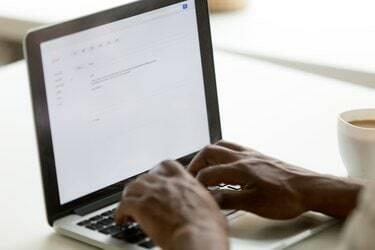 Pengusaha Afrika-Amerika mengetik email di laptop menggunakan aplikasi online