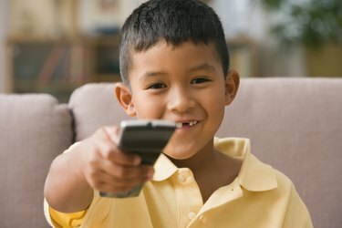 صبي صغير يستخدم جهاز التحكم عن بعد