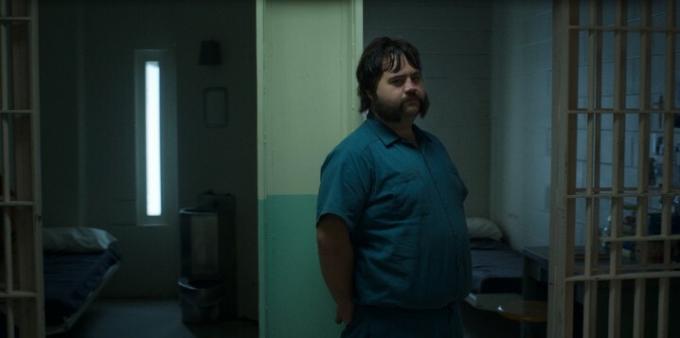 Paul Walter Hauser lutar sig mot dörren till sin karaktärs fängelsecell i en scen från Black Bird.