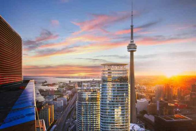 Torontos skyline med bygninger og C.N. tårn mot en solnedgang.