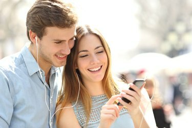زوجان يتشاركان الموسيقى من هاتف ذكي في الشارع