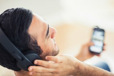 Close-up op knappe man die naar muziek luistert op zijn smartphone