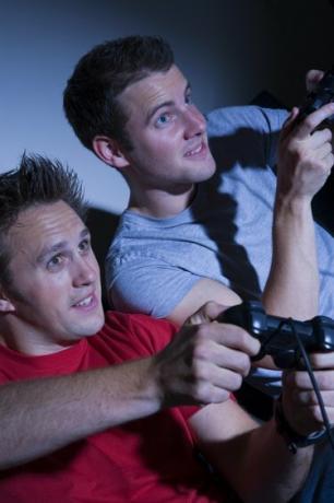 Dua pria bermain di konsol game