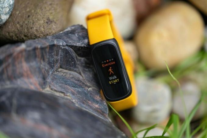 ساعة Fitbit Inspire 3 متكئة على صخرة.