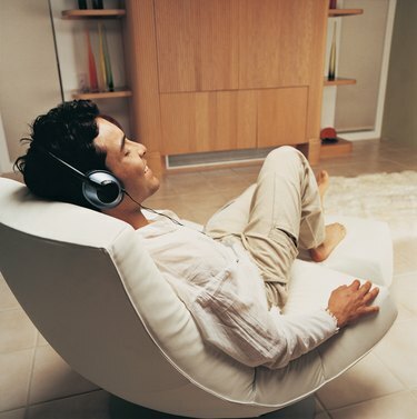 Bărbat care se relaxează cu muzică în camera lui de relaxare