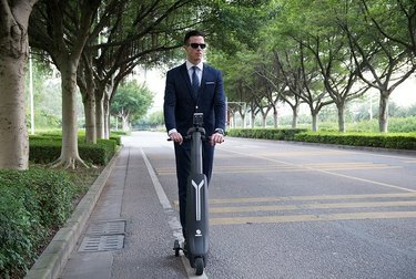 Hombre en traje de paseo en scooter eléctrico