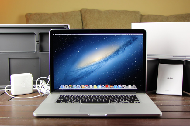 Een MacBook Pro op een bureau met een power brick erachter. Het OS X Mountain Lion-besturingssysteem is zichtbaar op het display.