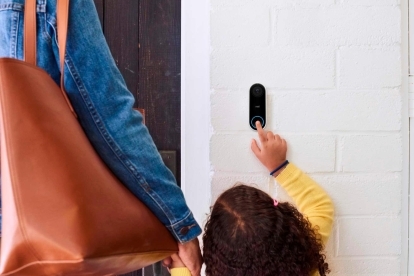 Ett barn som trycker på Google Nest Hello Video Doorbell.