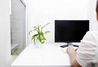 Задній вид молодий бізнес-леді за допомогою комп'ютера на столі