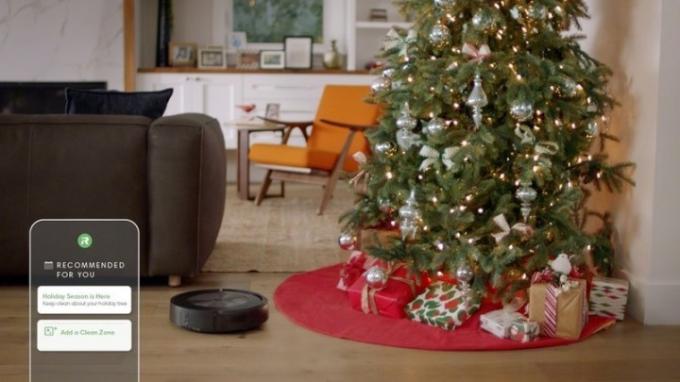 Az iRobot Roomba J7 robotporszívója karácsonyfa közelében.