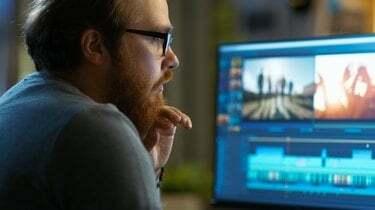 Editorul video masculin lucrează cu imagini și sunet pe computerul său personal. Lucrează într-un birou cool.