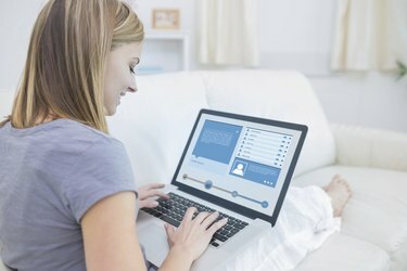 Žena sedí na gauči a kontroluje profil na sociálních sítích