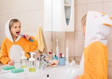 Kind, das Zähne in einem Badezimmer putzt