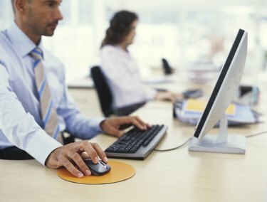 رجل أعمال يستخدم الكمبيوتر ، يدًا على الفأرة ، منظر جانبي