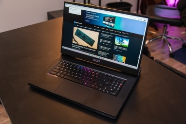 MSI GT77 Titan cu site-ul Digital Trends pe o masă.