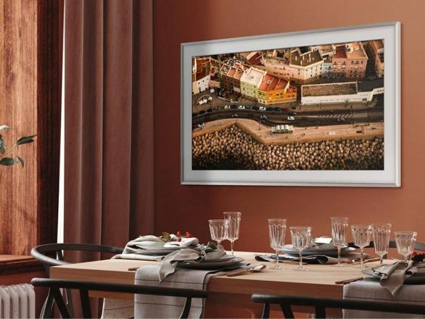 Una TV Samsung The Frame 4K da 55 pollici è appesa a una parete in una sala da pranzo.