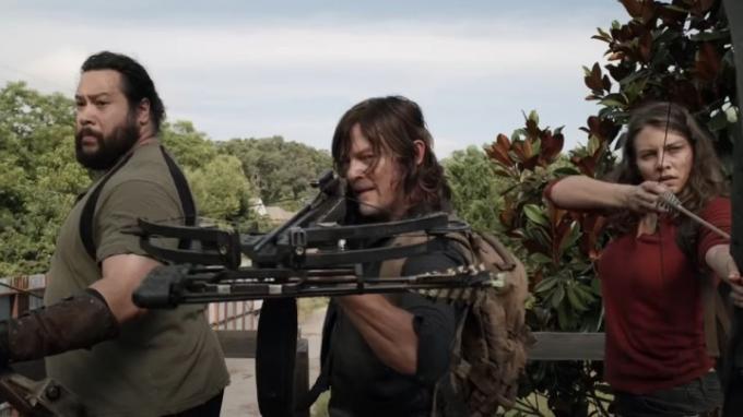 Drei Darsteller von The Walking Dead mit gezogenen Waffen.