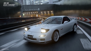 Sebuah Mazda Rx 7 melayang di tengah hujan di Jalan Tol Tokyo di Gran Turismo 7.