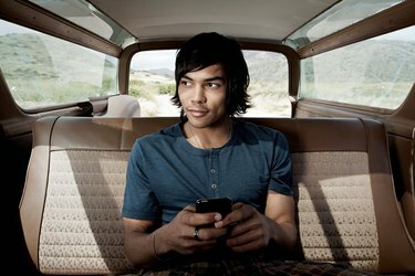 スマートフォンを使用して車内の若い男