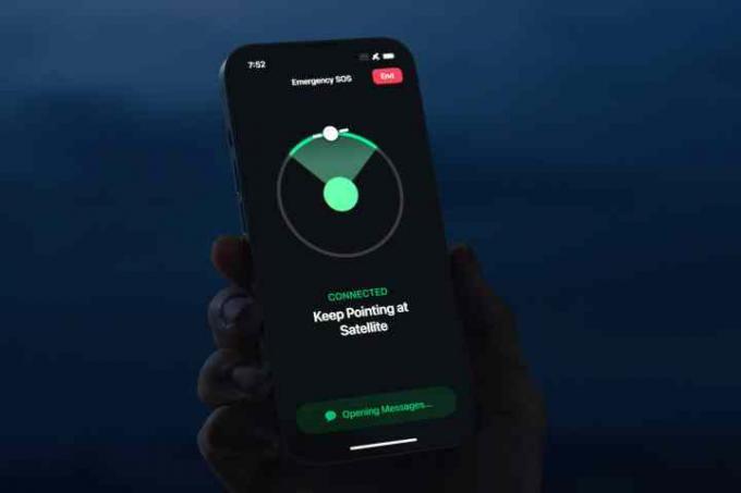 Person som håller iPhone 14 söker efter SOS-satellit för nödsituationer.