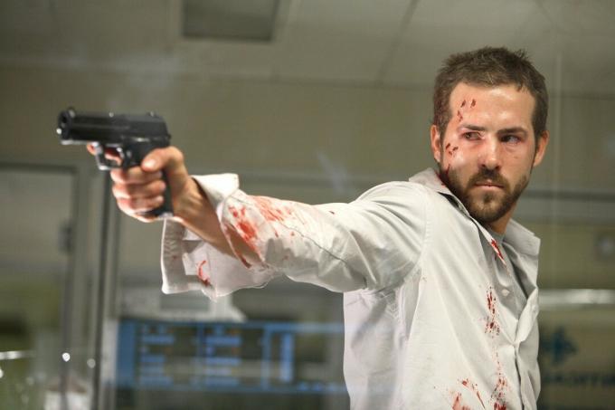 Ryan Reynolds míří pistolí ve Smokin' Aces.