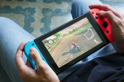 Een persoon speelt Mario Kart 8 Deluxe op een Nintendo Switch in handheldstijl.