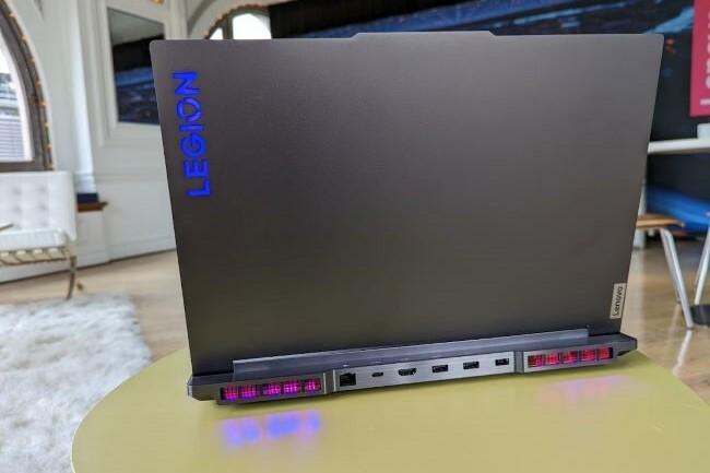 Záber notebooku Lenovo Legion 7 zo zadnej strany so zobrazeným logom a osvetlením RGB na stole.