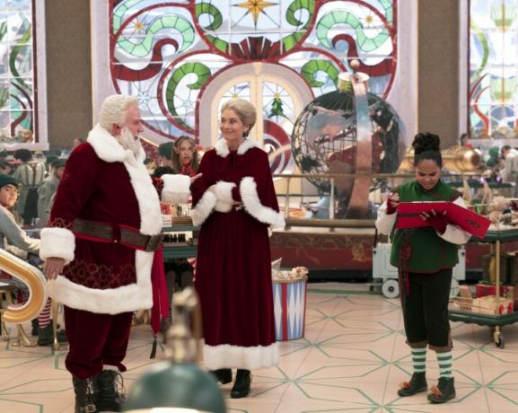 Tim allen in Elizabeth Mitchell kot Božiček in ga. Božiček stoji v tovarni igrač v prizoru iz Božičkov.