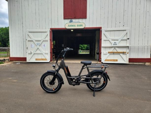 Rad Power Bikes RadRunner 3 Plus გაჩერებულია პარკში ცხოველთა ბეღელის წინ.