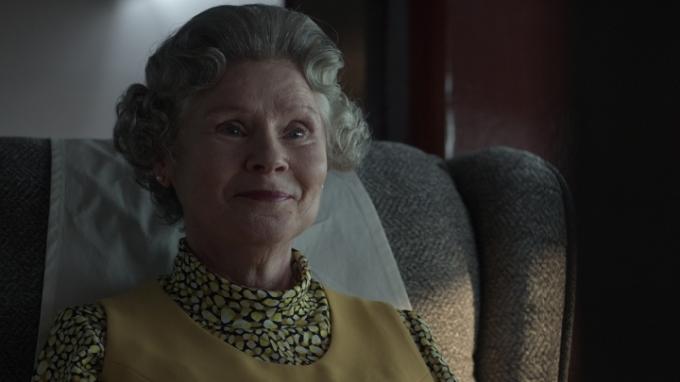 A Rainha da 5ª temporada de The Crown, sentada e sorrindo.