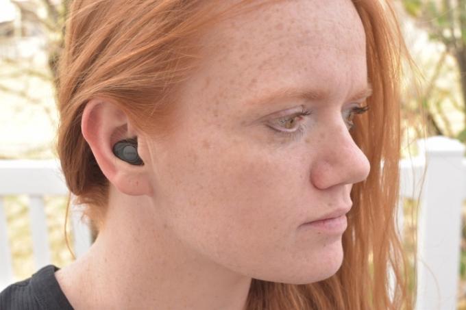Kobieta nosi słuchawki douszne Jabra Enhance Plus.